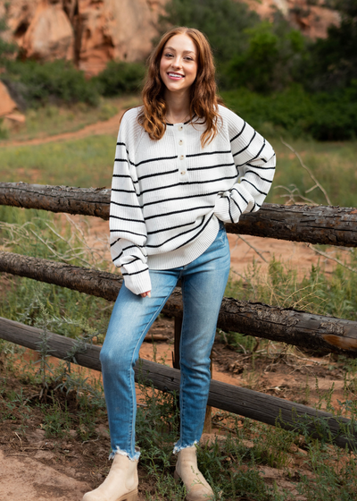 Long sleeve ivory sweater with buttons at the neck and black stripes