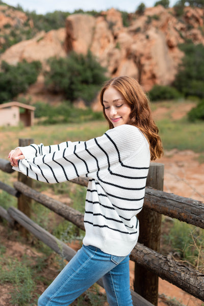 Side view of a long sleeve ivory sweater