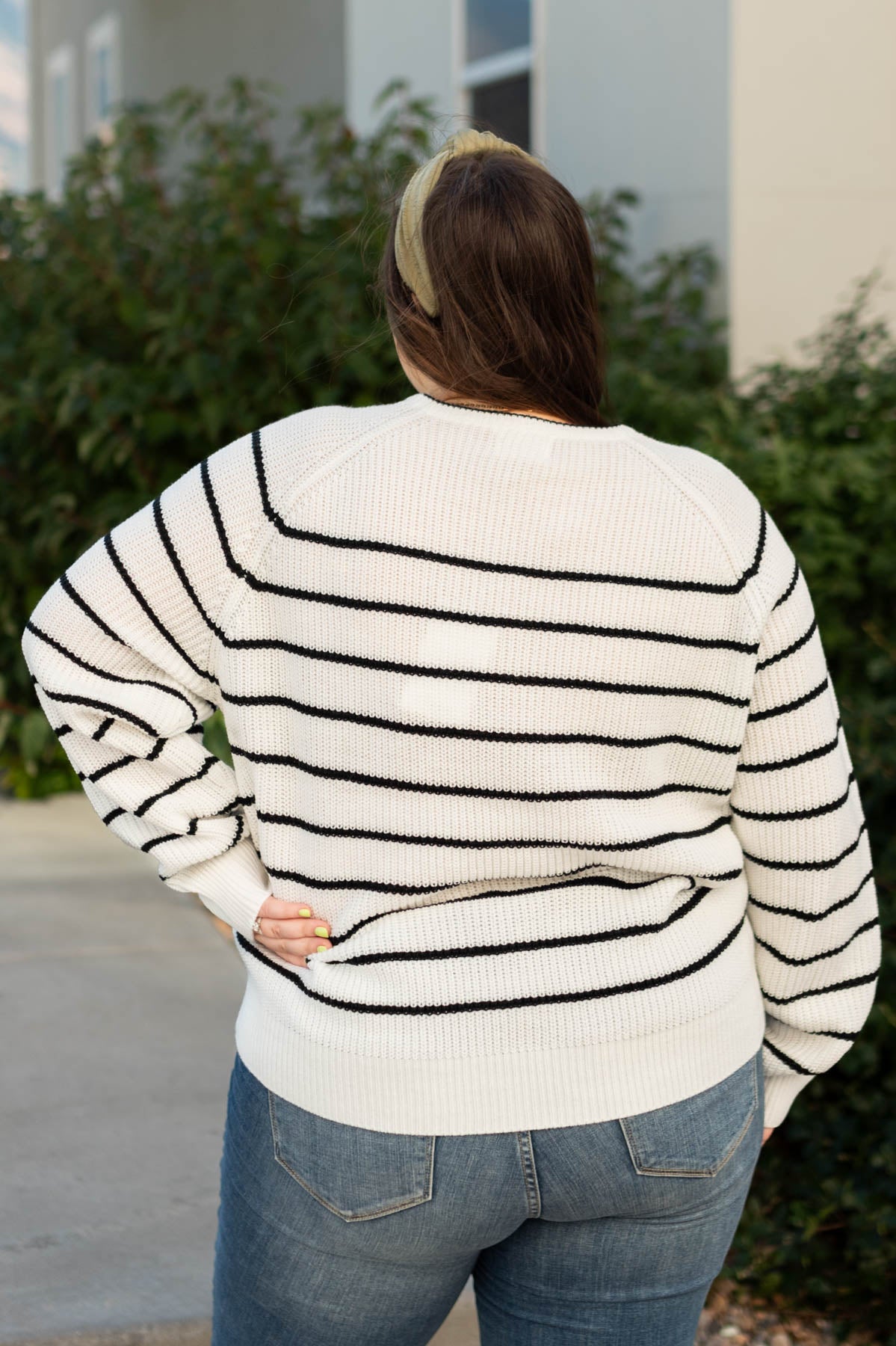 Back view of a plus size ivory sweater with