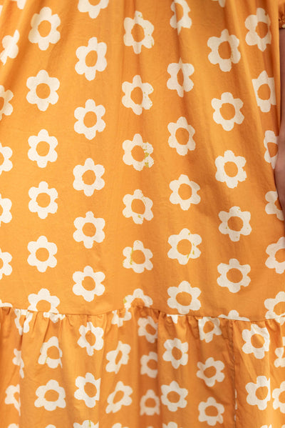 Close up of the print on the golden floral dress