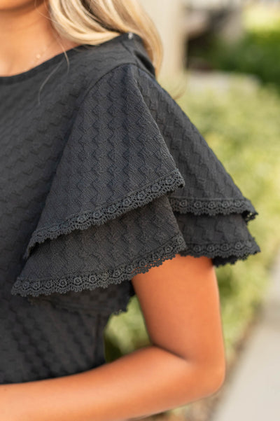 Black top with ruffles for sleeves