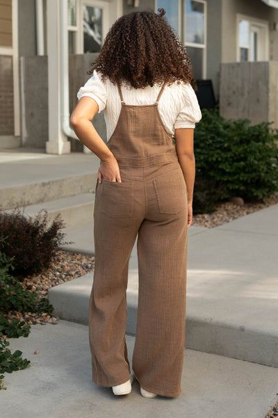 Back view of a brown jumpsuit with back pockets