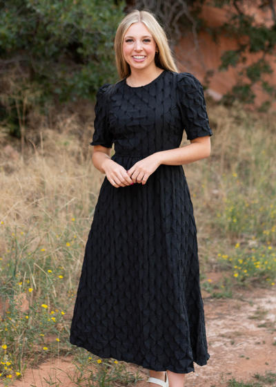 Black dress with short sleeves and pin tuck fabric design