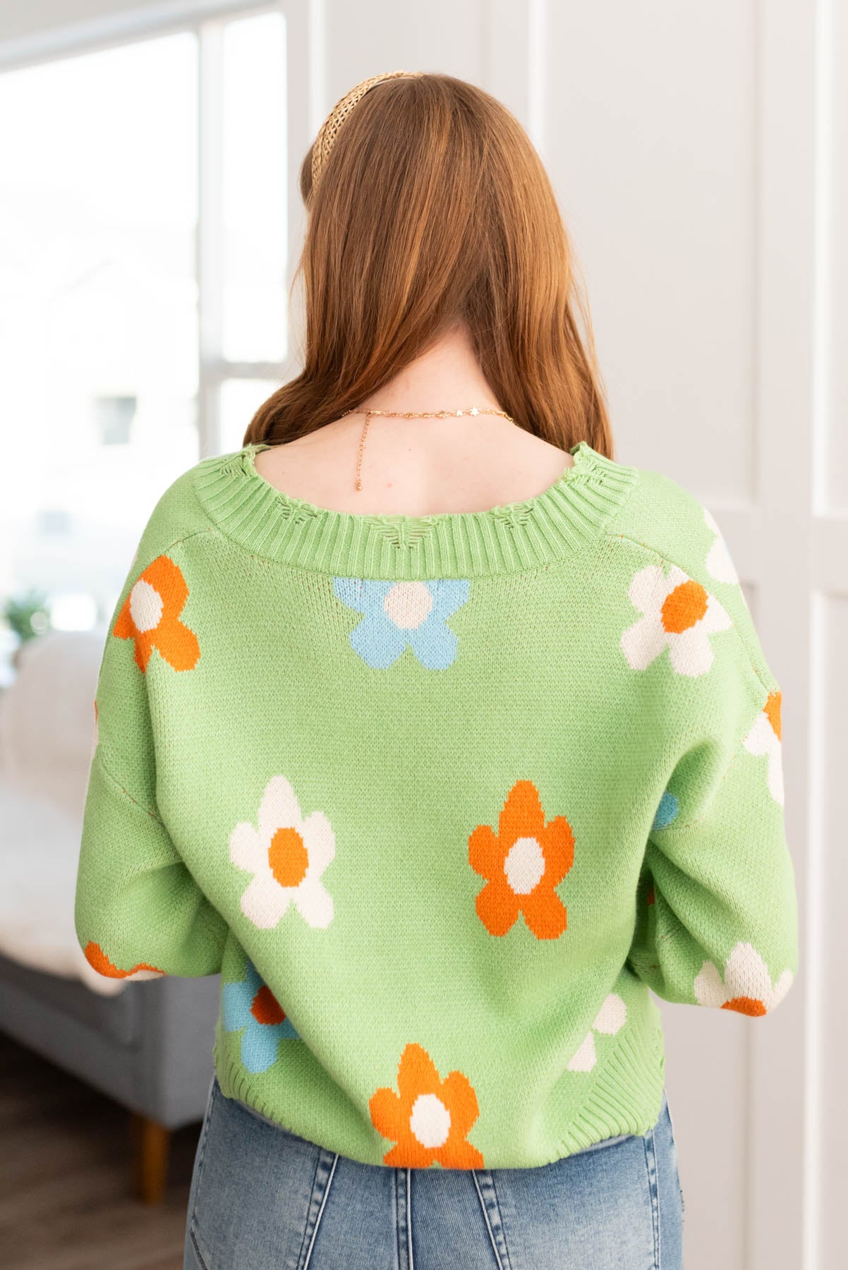 Back view of a green floral sweater