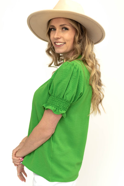 Elastic on short sleeve of a kelly green top