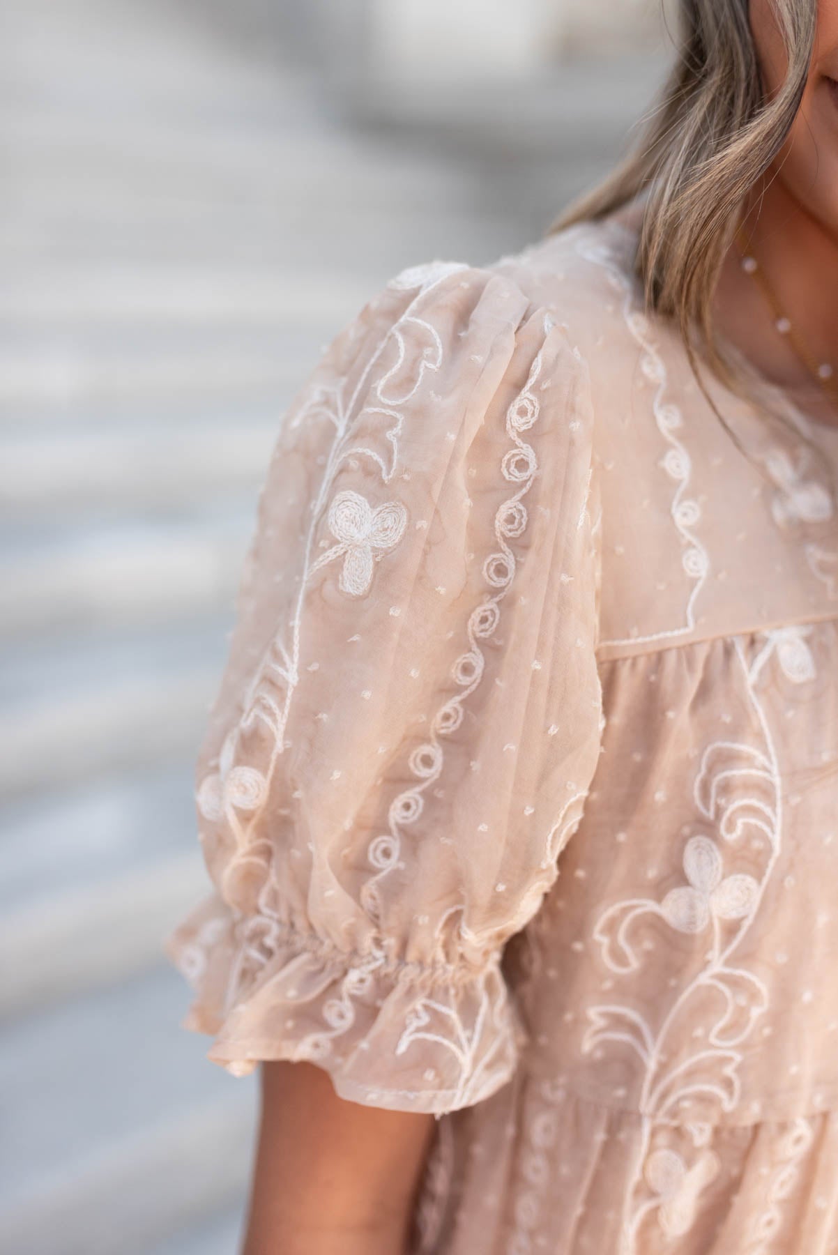 Close up of the sleeve on the beige embroidered dress