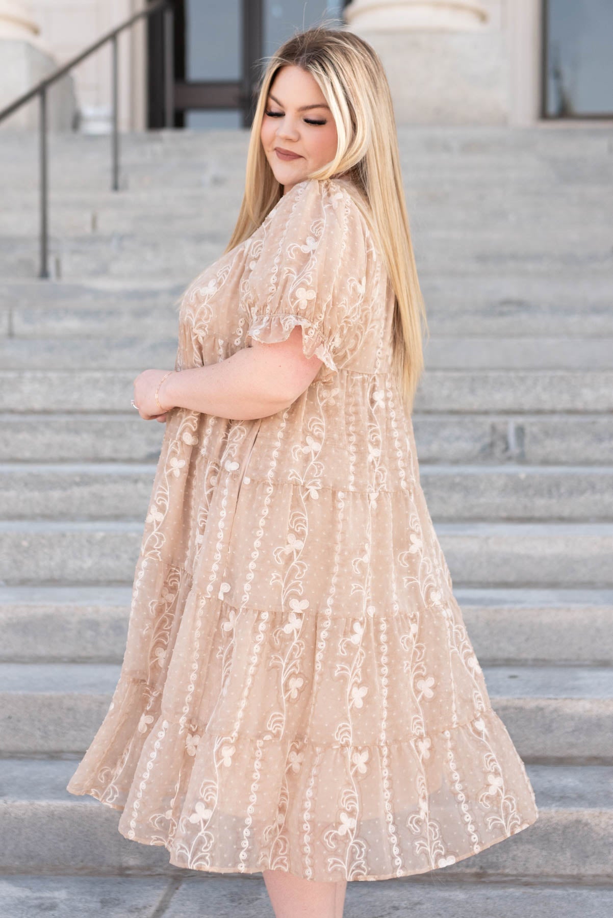 Side view of a plus size beige embroidered dress