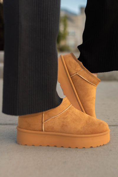 Side view of tan slippers with low platform 