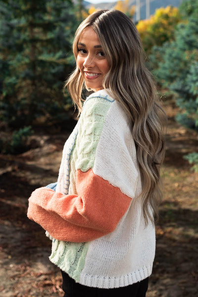 Side view of a pastel color block knit multi sweater