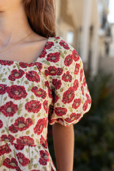 Close up of the fabric and sleeve of the red floral dress