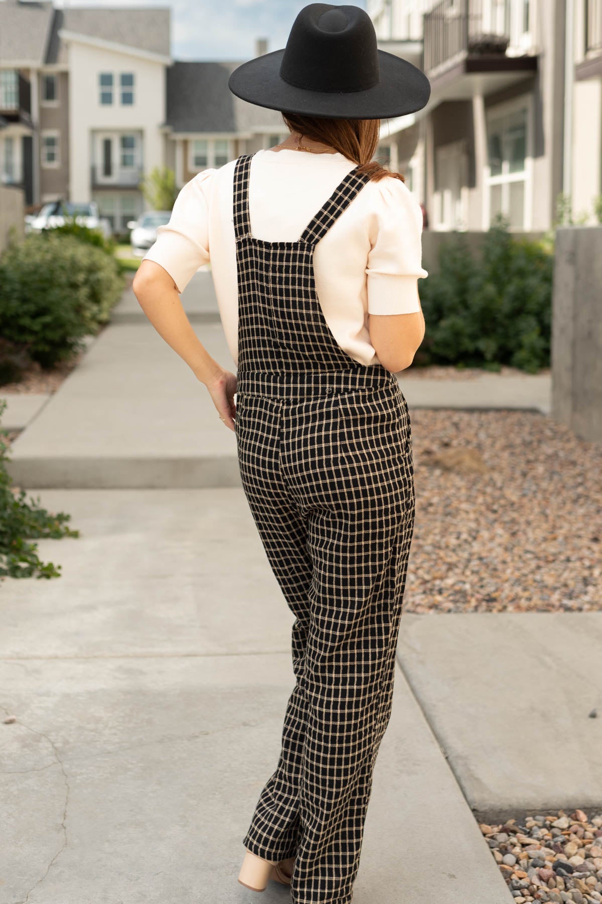 Back view of a black plaid overalls