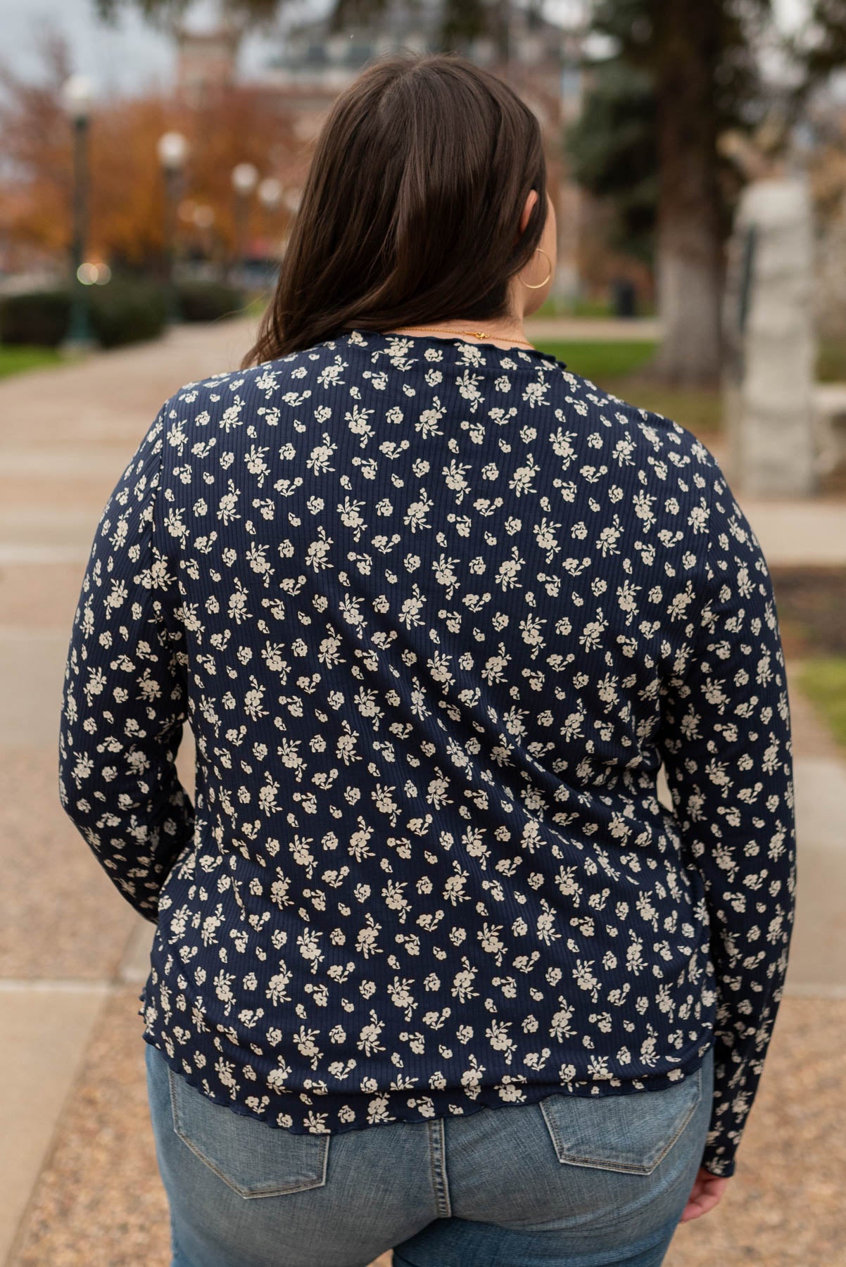 Back view of a plus size navy flower print long sleeve top