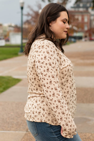 Side view of the plus size sand flower print long sleeve top