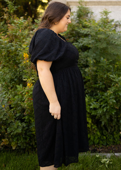 Side view of a plus size short sleeve black dress