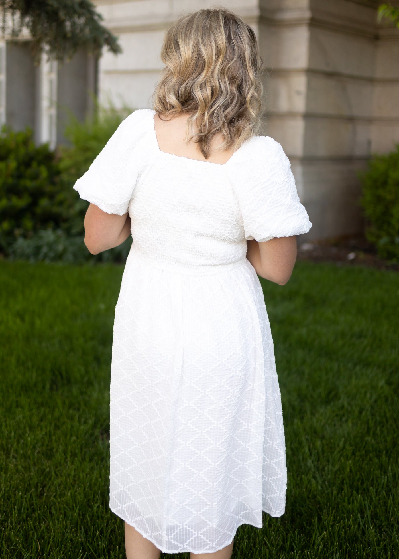 Back view of a white dress with puff sleeves