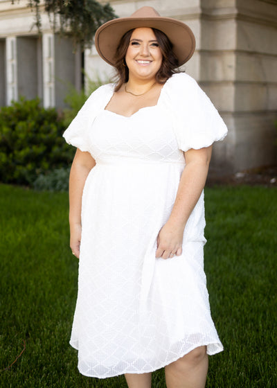 Front view of a plus size white dress with puff sleeves