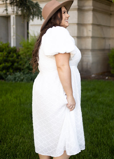 Side view of a plus size white dress with puff sleeves