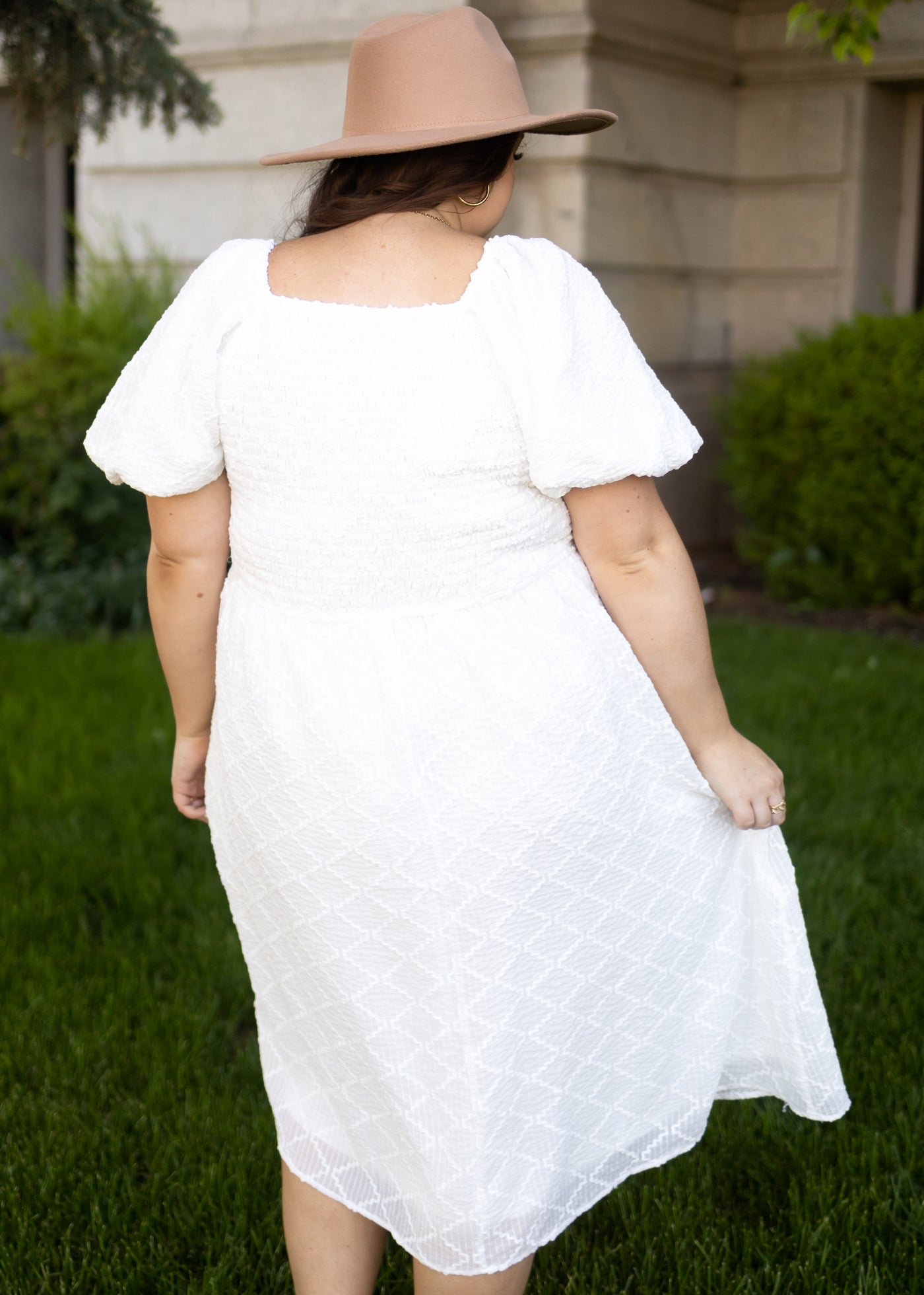 Back view of a plus size white dress with puff sleeves