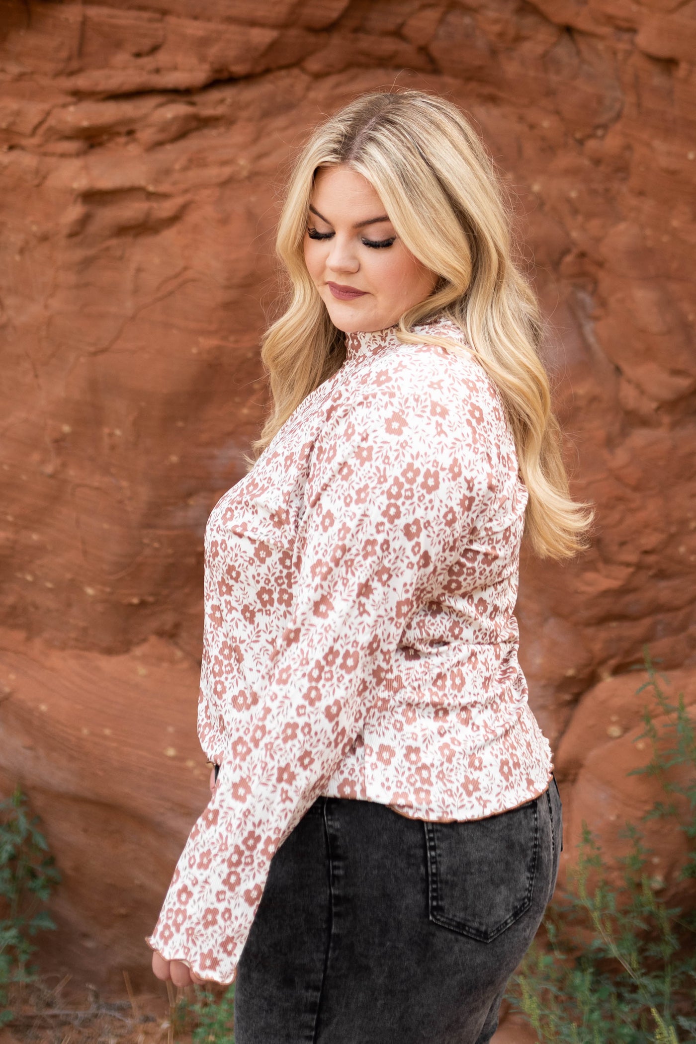 Side view of a plus size brown floral top
