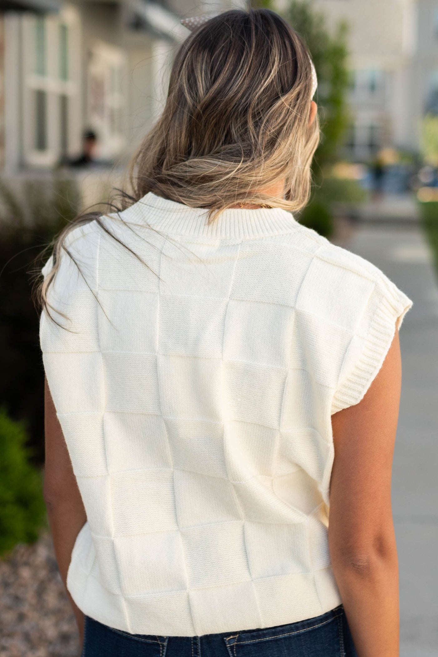 Back view of a ivory sweater vest