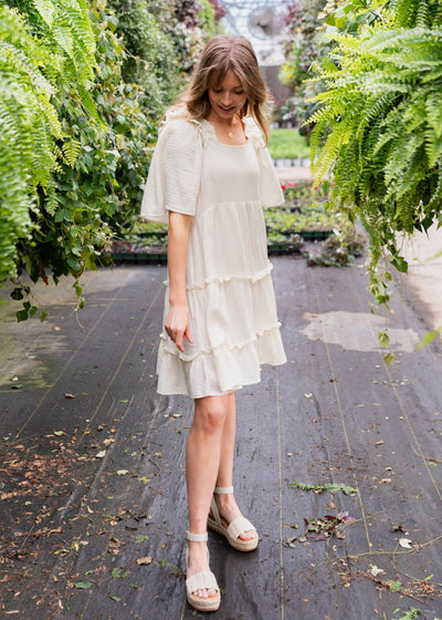 Ivory mini dress with ruffles at the neck