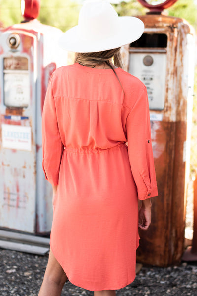 Back view of a Terracotta dress with collar and buttons that ties at the waist 