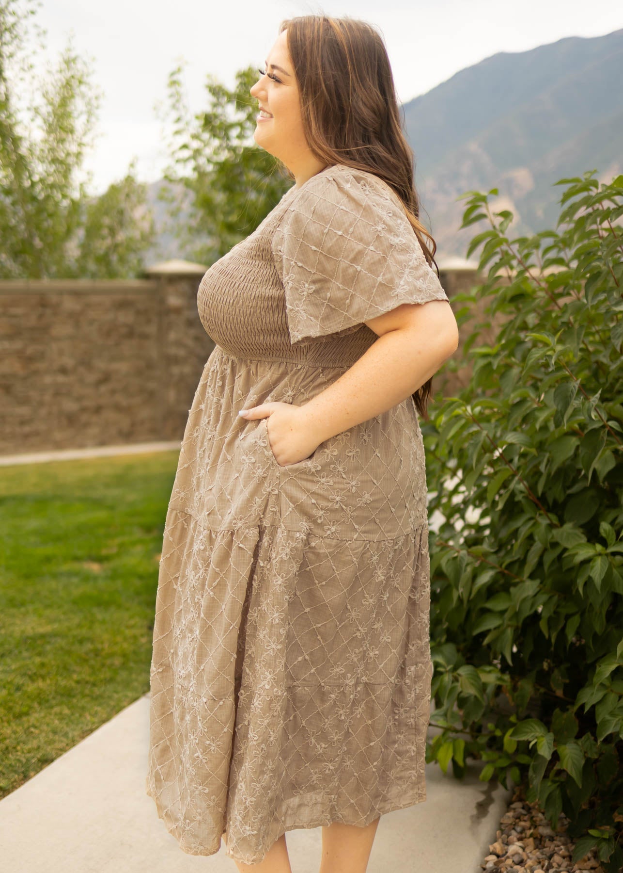 Side view of a plus size taupe dress