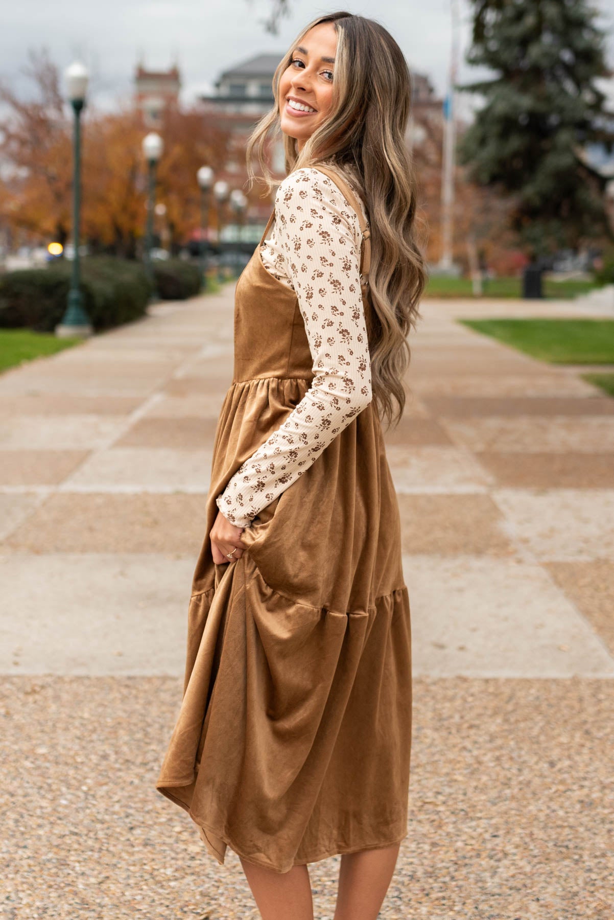 Side view of tiered skirt camel jumper dress
