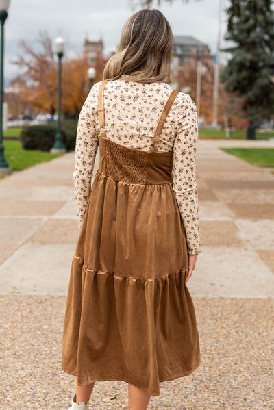 Back view of a camel jumper dress with elastic smocking
