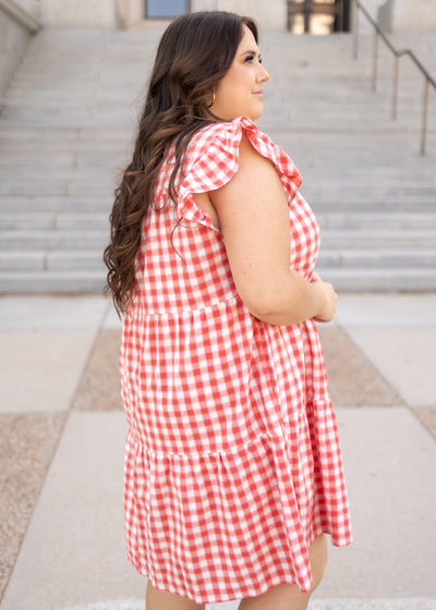 Side view of a plus size red gingham dress with cap sleeves