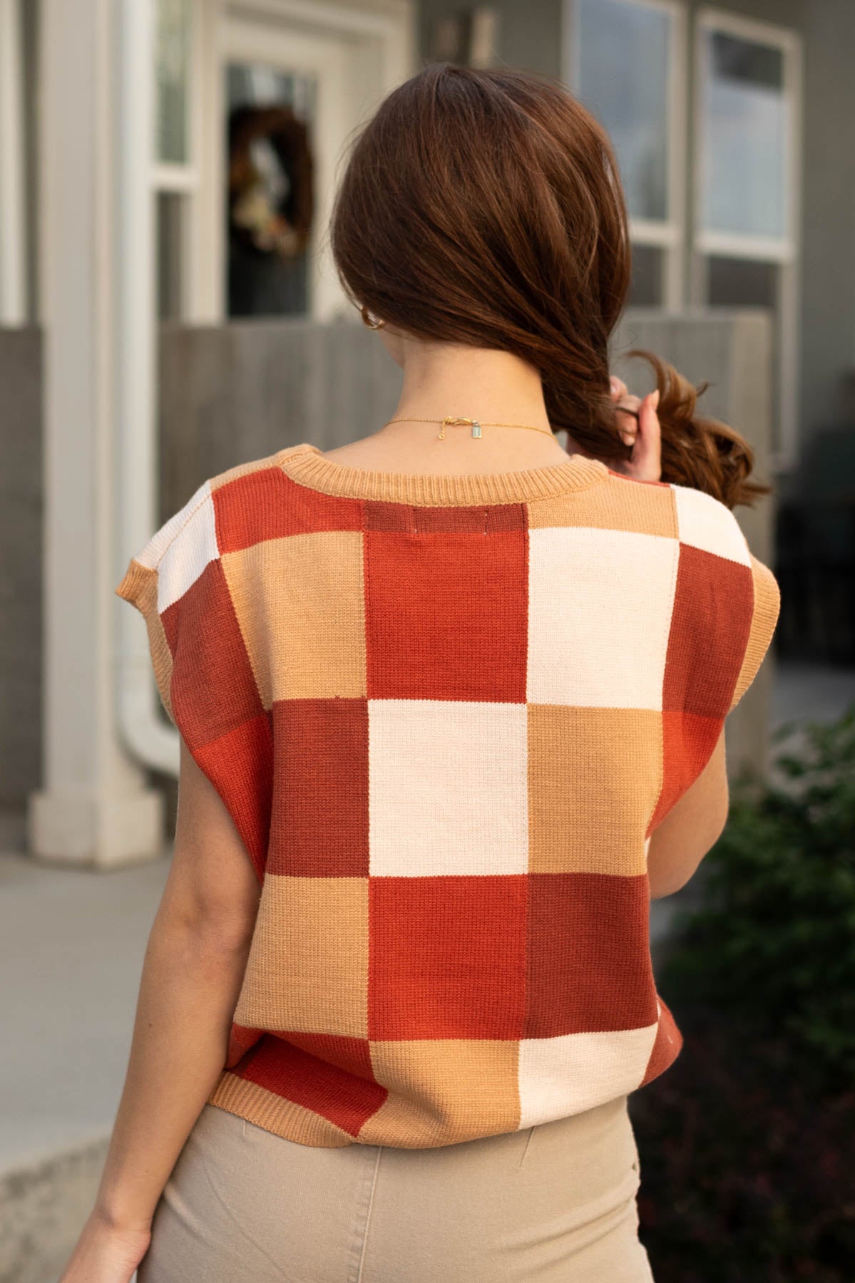 Back view of a checkered sweater vest