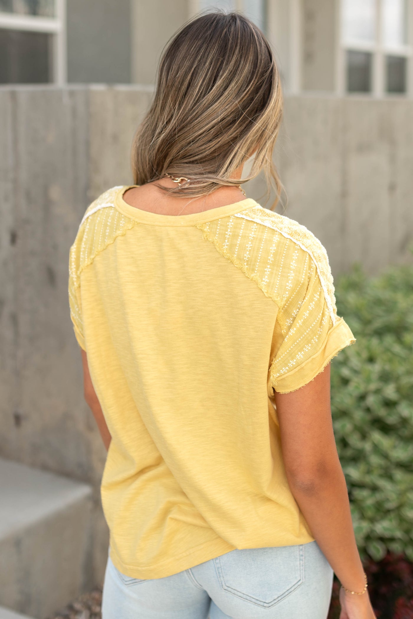 Back view of a short sleeve marigold top