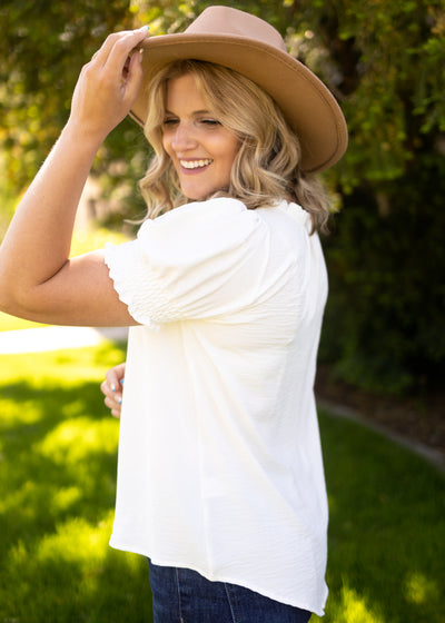 Side view of a short sleeve white top with elastic on sleeve