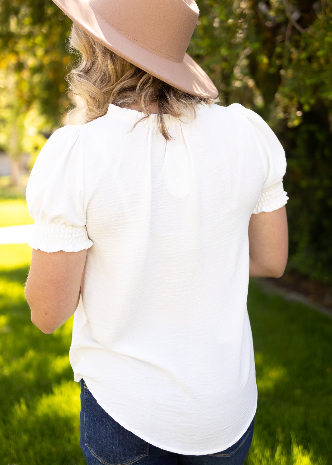 Back view of a short sleeve white top with elastic on sleeve