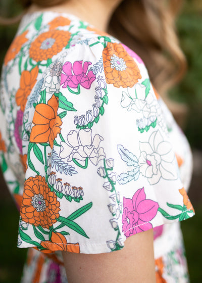Sleeve of a plus size tan floral dress