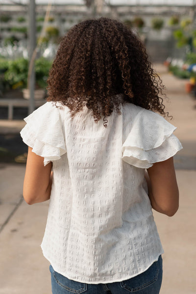 White ruffle sleeve top shown from the back