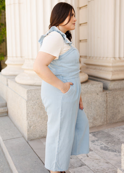 Side view of the plus size denim jumpsuit with pockets