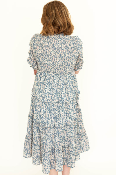 Back view of a short sleeve blue floral tiered dress.