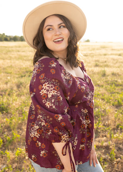 Side view of a plus size plum floral top