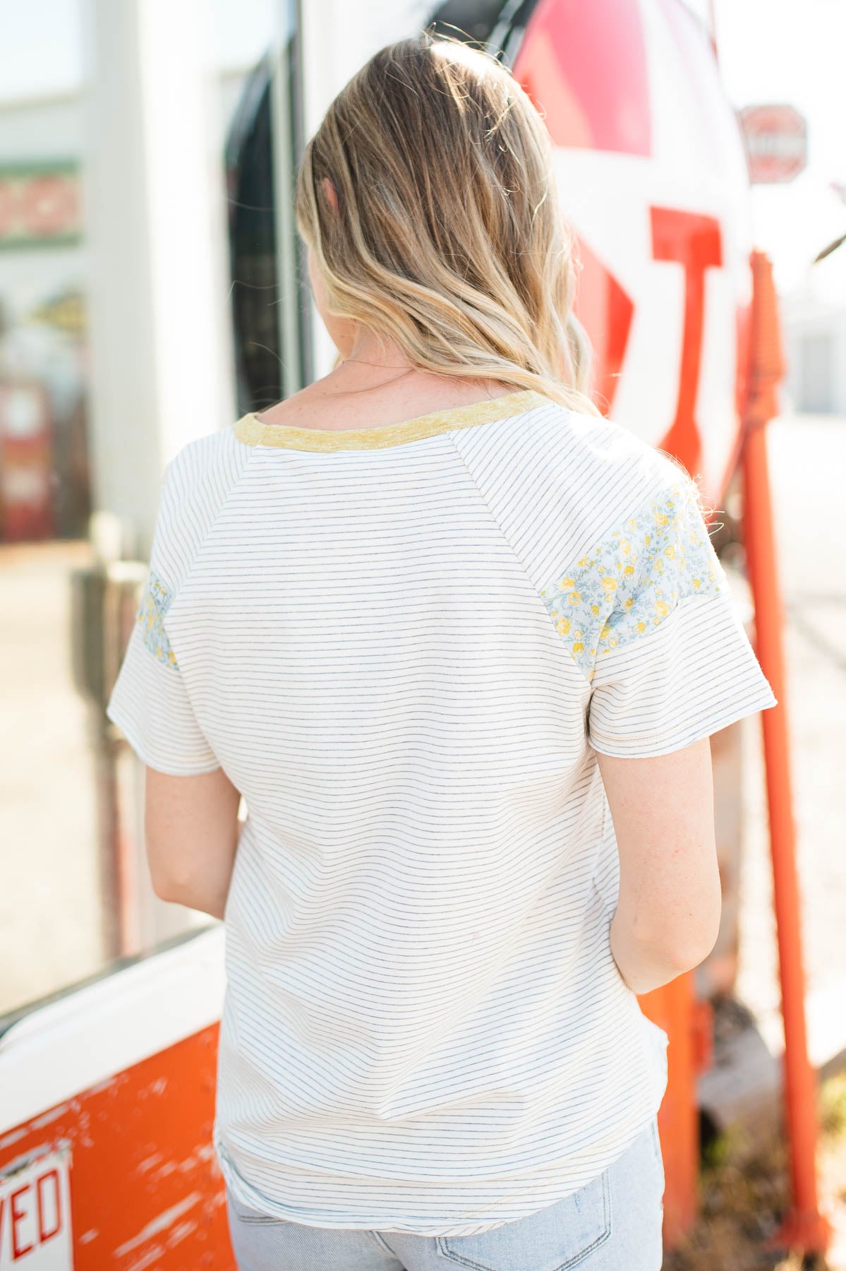 Back view of white stripe top with flower pattern on sleeve