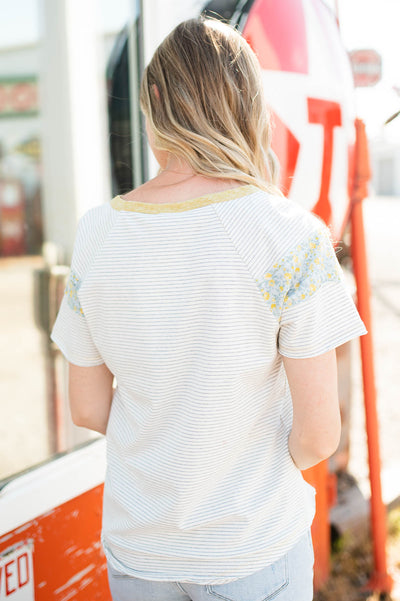 Back view of white stripe top with flower pattern on sleeve