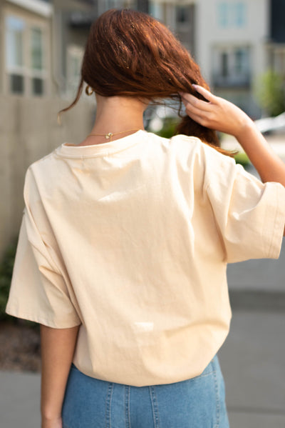 Back view of a cowgirl sand tee