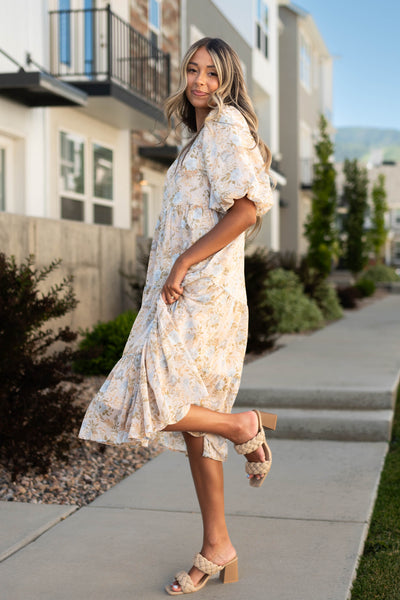 Side view of a short sleeve blush dress with a flower print