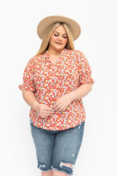 Front view of a plus size red floral short sleeve top