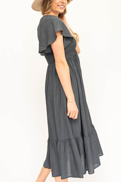 Side view of a short sleeve vintage blue satin dress with a V-neck and smocked bodice.