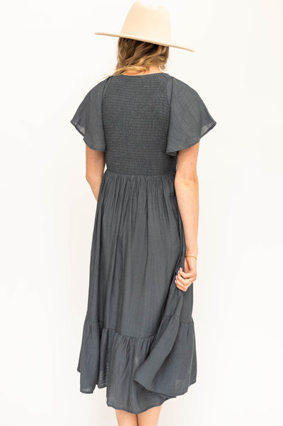 Back view of a short sleeve vintage blue satin dress with a V-neck and smocked bodice.