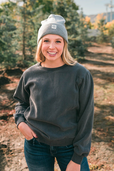 Front view of a heather grey smiley beanie