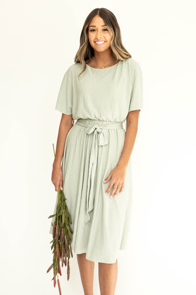 Front view of a short sleeve sage colored dress