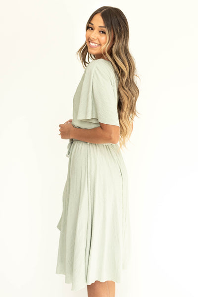 Side view of a sage colored dress with short sleeves