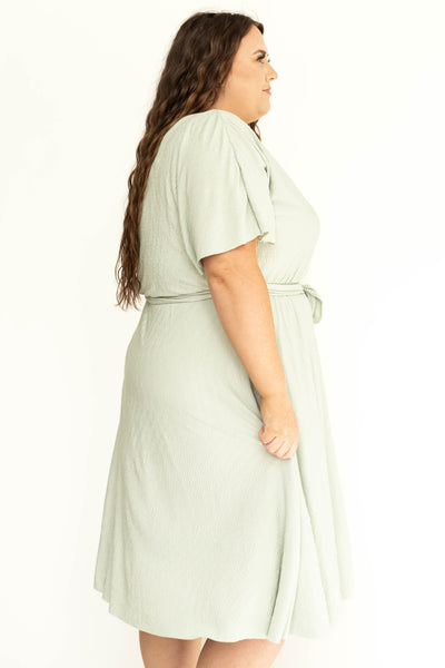 Side view of a plus size sage colored dress